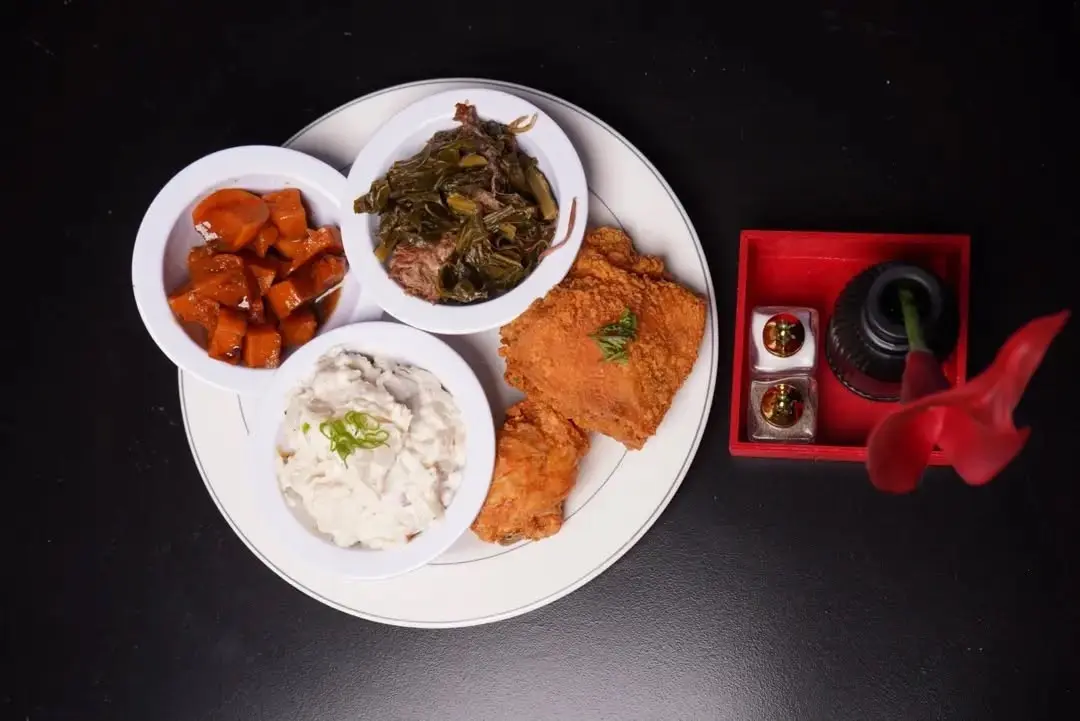 A Soul Food on 68 plate of fried chicken with candied yams, collard greens, and potato salad